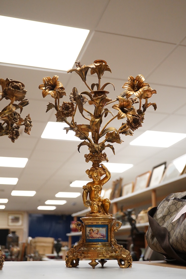 A pair of 19th century brass four light figural candelabra with inset enamel plaques, 48cm high